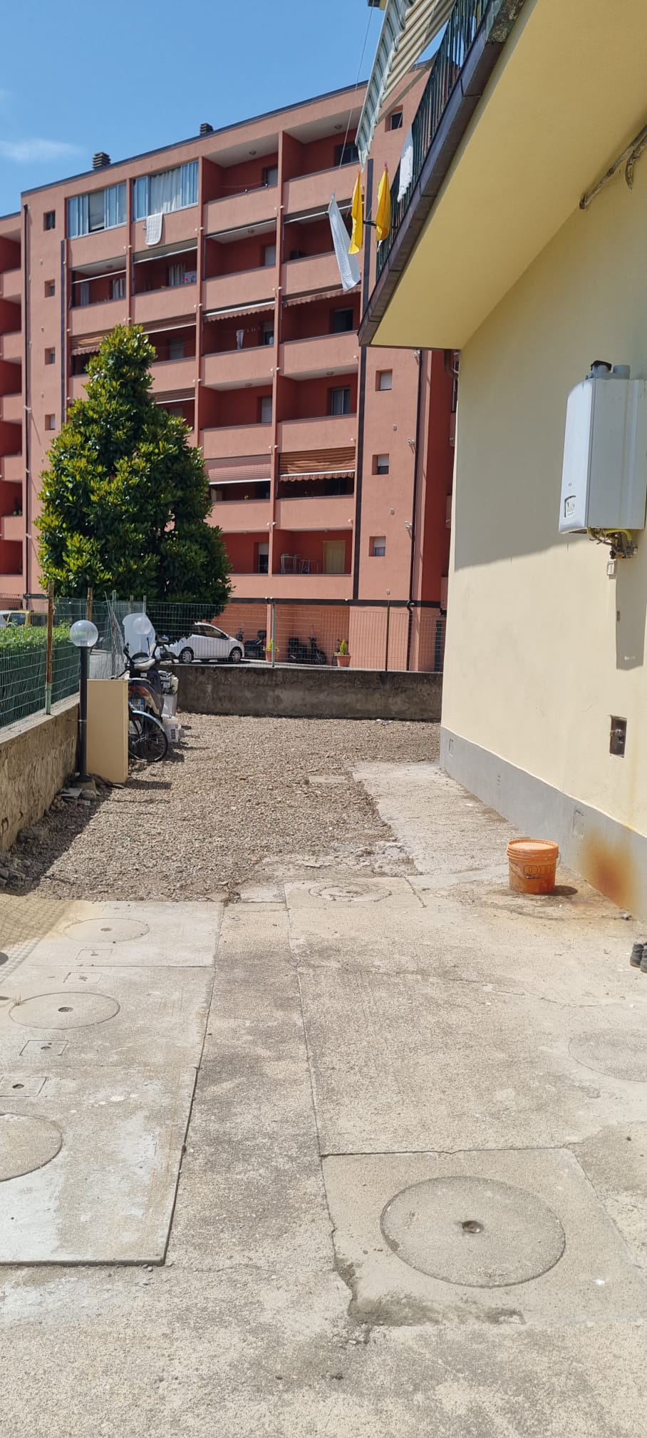 Corte condominiale a Sesto Fiorentino dopo il diserbo — ghiaia livellata e passaggi liberi